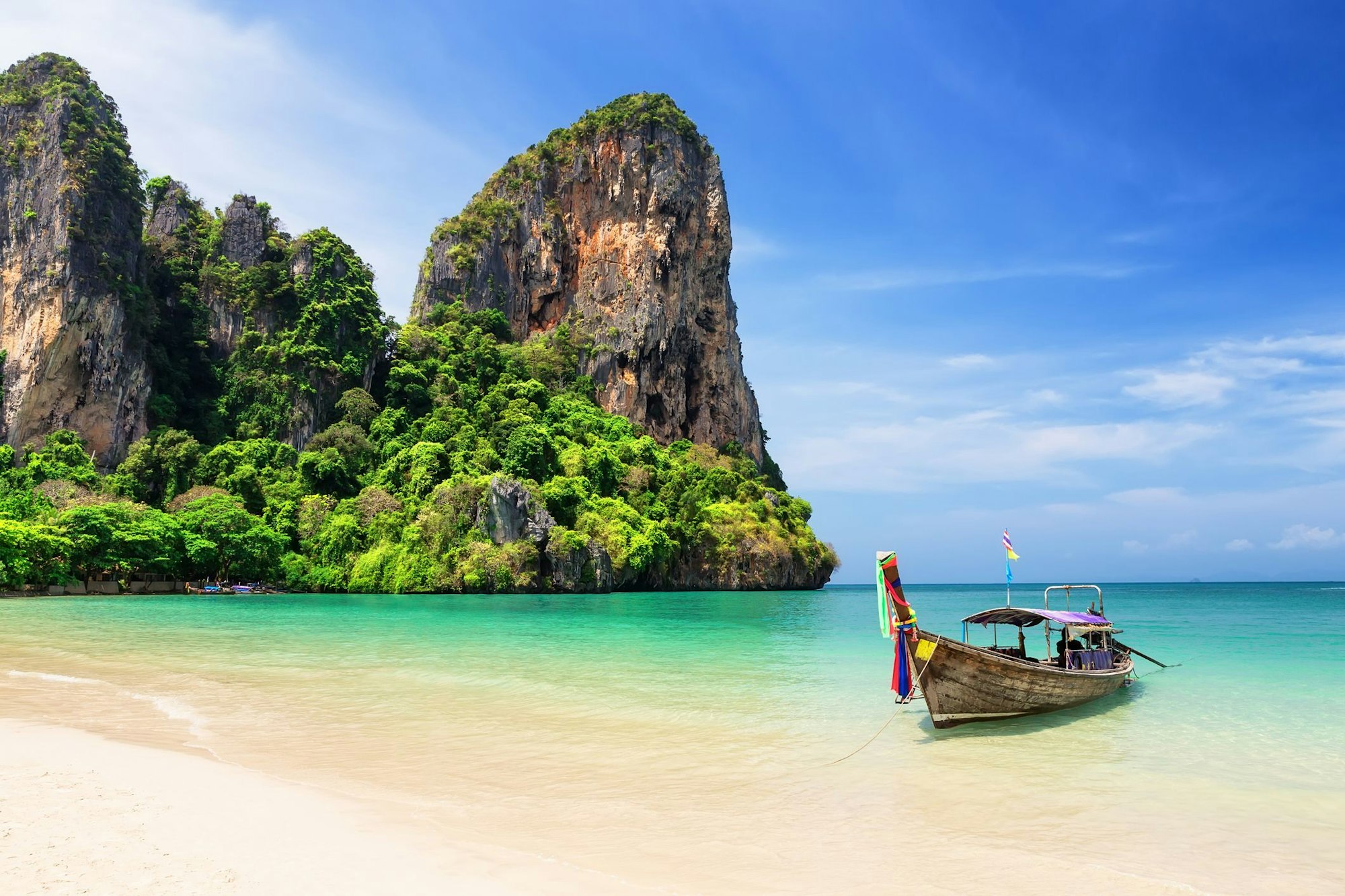 Ein Fischerboot liegt in einer Bucht in Thailand.