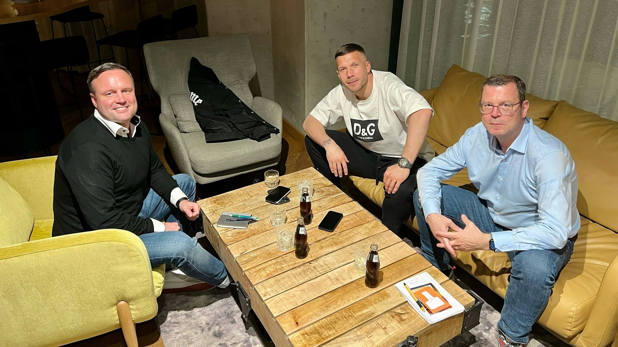 Zu Besuch bei Lukas Podolski (m.): Chefredakteur des „Kölner Stadt-Anzeiger“, Carsten Fiedler (r.), zusammen mit Sportredakteur Lars Werner beim Gespräch mit dem ehemaligen Profi des 1. FC Köln.