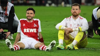 Jonas Hector und Timo Horn sitzen vor der Südkurve des 1. FC Köln.