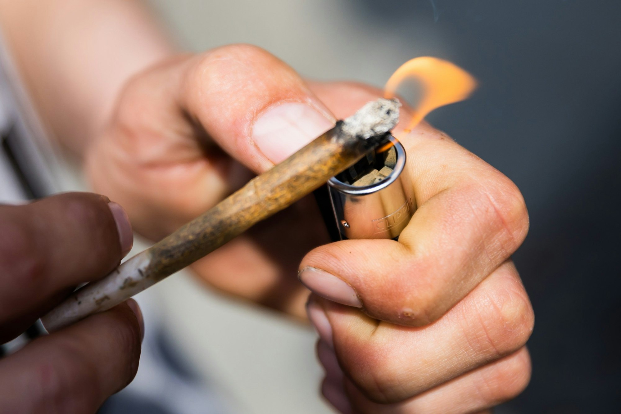 Ein Mann zündet einen Joint mit Medizinalcannabis an.