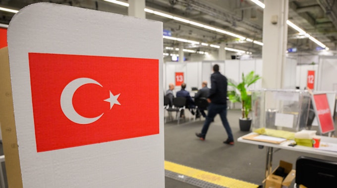 Ein Wahlkabine mit einer Flagge steht in einem Wahllokal für die türkische Präsidentschaftswahl in der Messe Hannover.