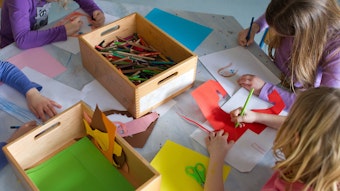 Das Foto zeigt, wie Kinder in einer Kita malen und basteln.