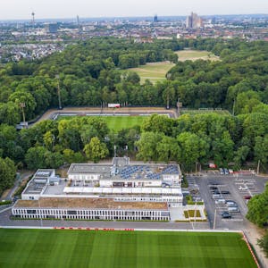 Das Geißbockheim genannte Clubhaus des Fußballverein 1. FC Köln mit dem Trainingsplatz 1 (vorne) und dem Franz-Kremer-Stadion (hinten) im Äußeren Grüngürtel. Im Hintergrund sind das Stadtzentrum und der Beethovenpark zu erkennen.