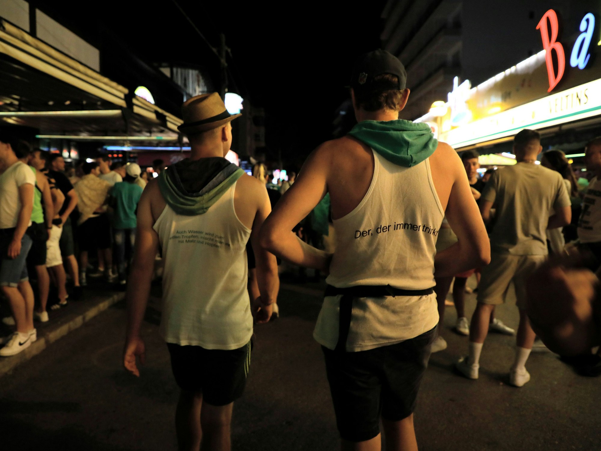 Vorwiegend junge Leute gehen am Abend des 1. Juli 2022 durch die Schinkenstraße im Party-Viertel Ballermann auf Mallorca.