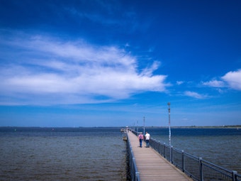 Spaziergänger sind auf der Seebrücke an der Ostseeküste in Wismar unterwegs.