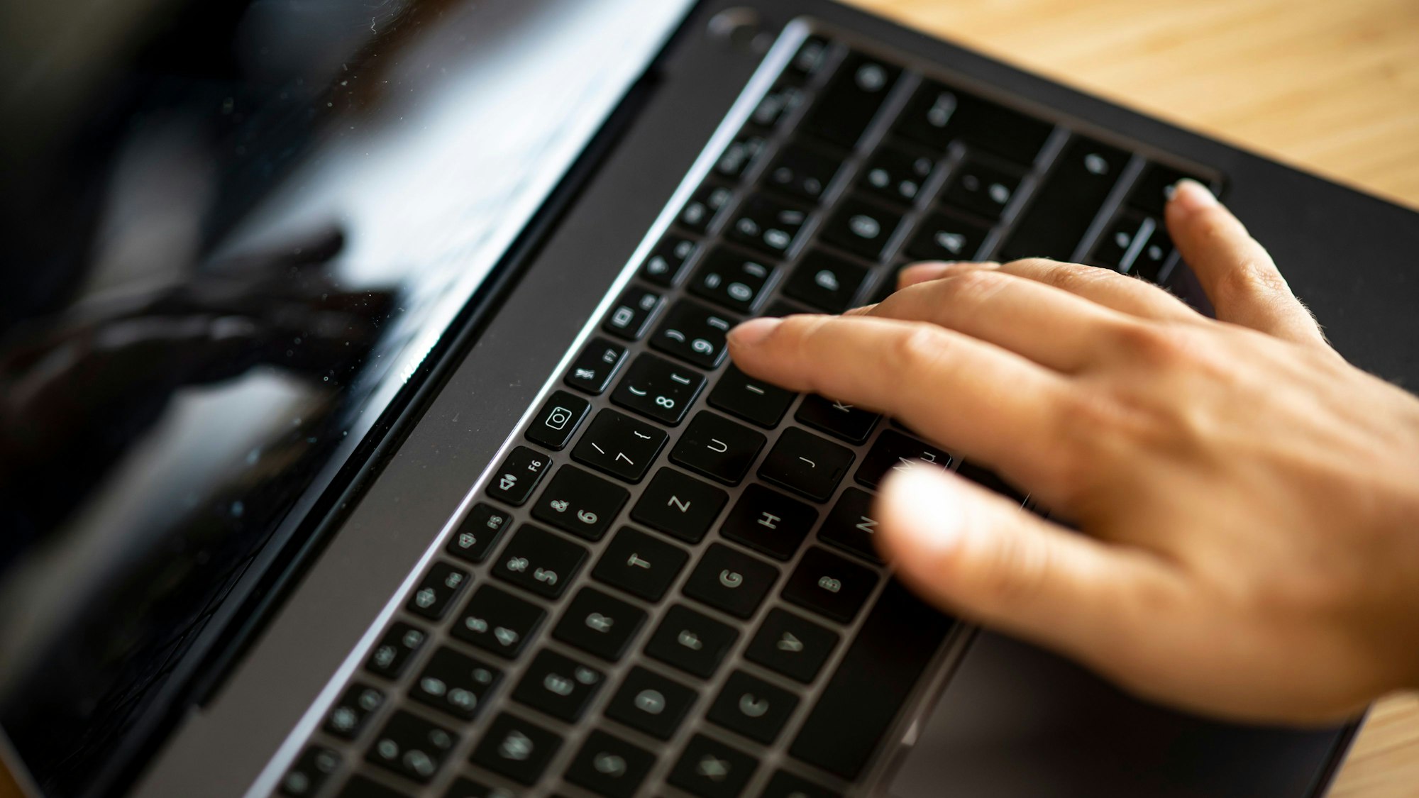Ein Mann tippt auf der Tastatur eines Laptops. (Symbolbild)