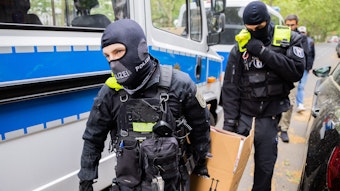 Polizisten tragen bei einer Hausdurchsuchung in Berlin-Kreuzberg einen Karton zu einem Fahrzeug. Polizei und Staatsanwaltschaft haben im Zuge eines Ermittlungsverfahrens zu Mitgliedern der „Letzten Generation“ 15 Objekte in sieben Bundesländern durchsucht.