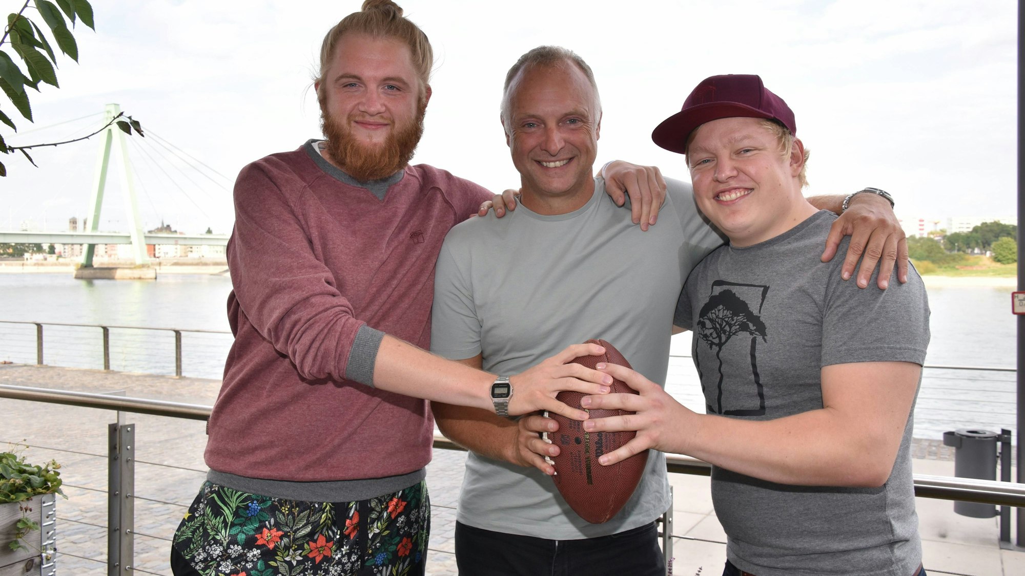 „Icke“ Dommisch, Frank Buschmann und Florian Schmidt-Sommerfeld halten einen Football in den Händen