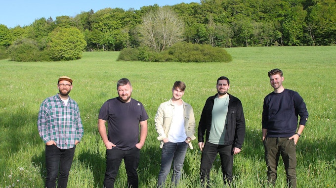 Das Bild zeigt die fünf jungen Musiker der Band „Amie &amp; Me“&nbsp; auf einer grünen Wiese.
