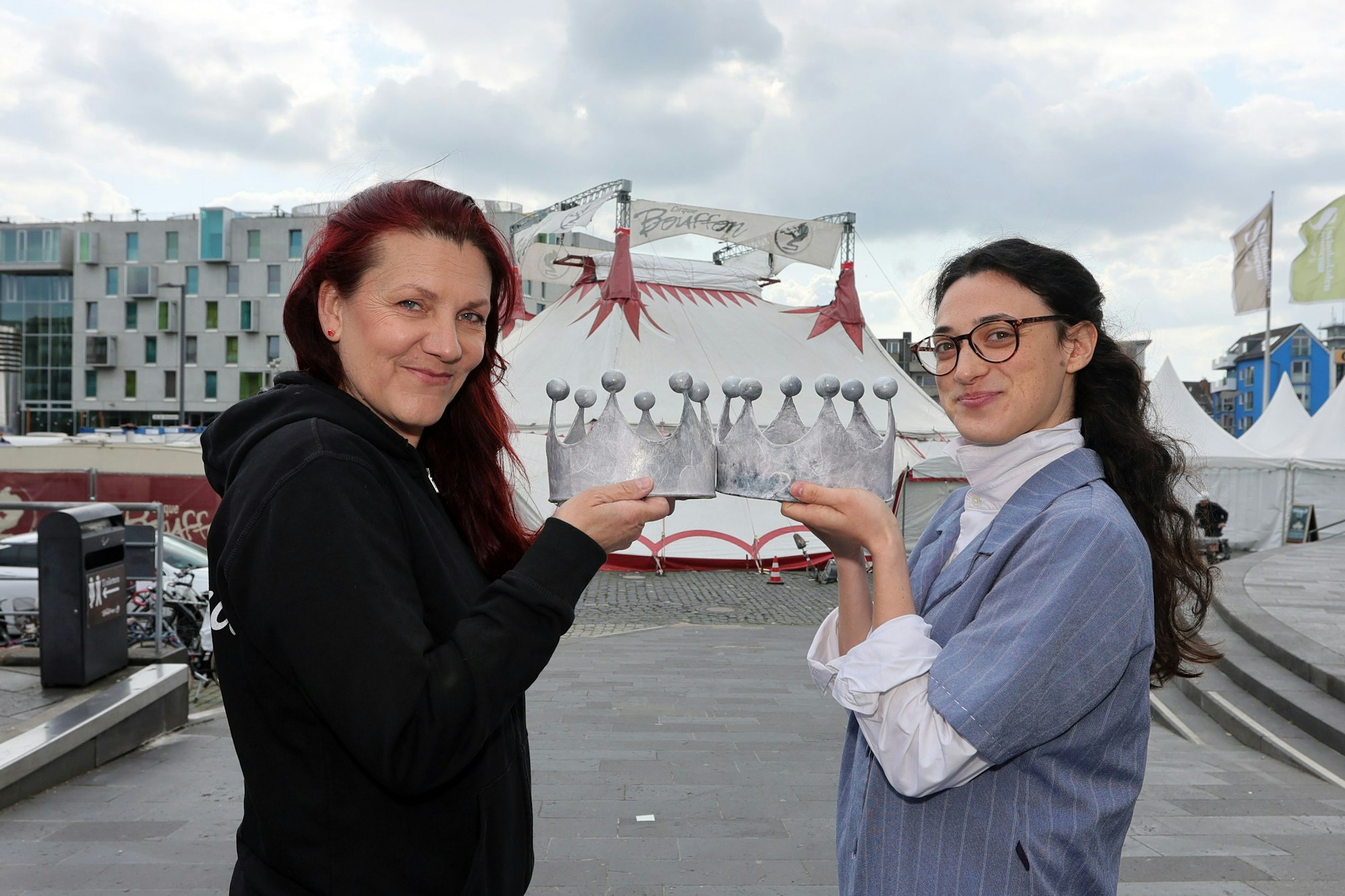 Anja Krips und Noémie Pichereau halten zwei Kronen und stehen sich damit gegenüber.