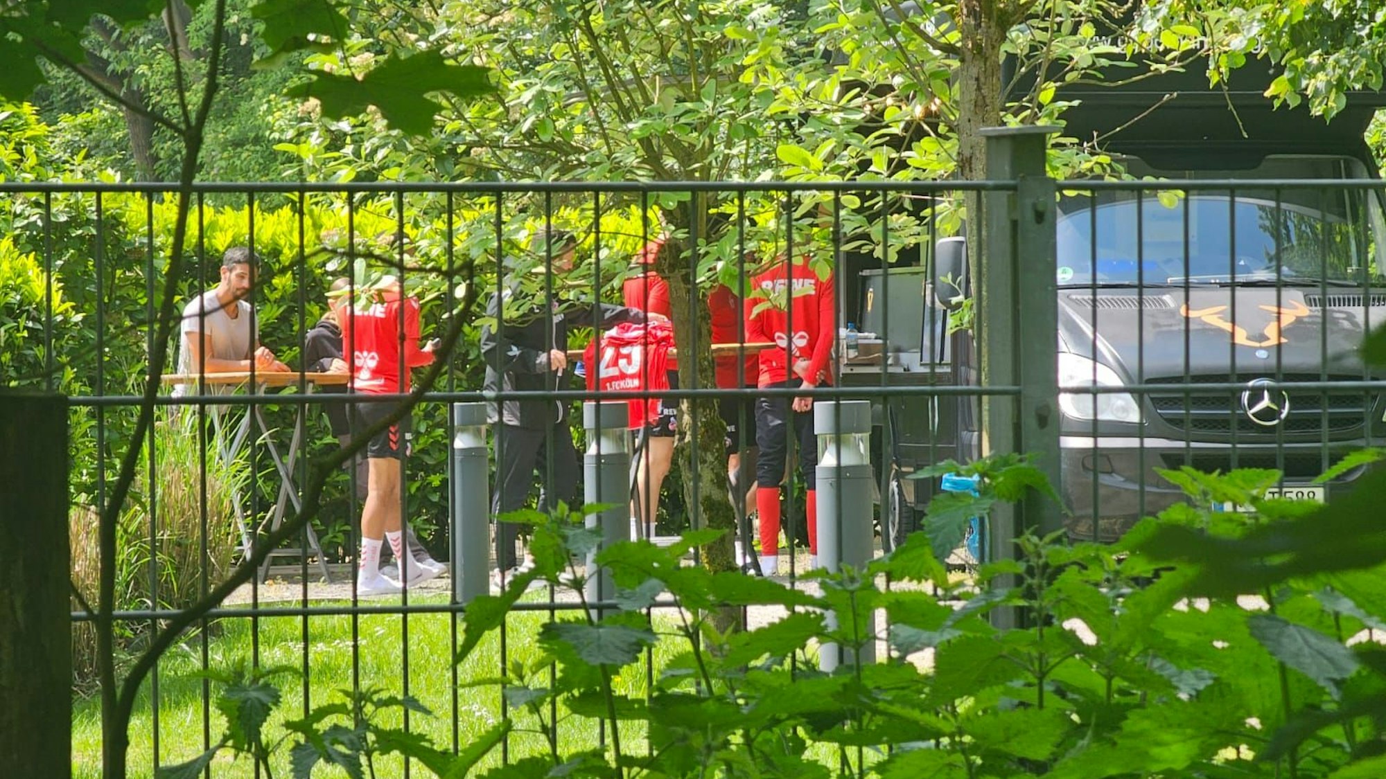 Spieler des 1. FC Köln stehen vor einem Foodtruck.