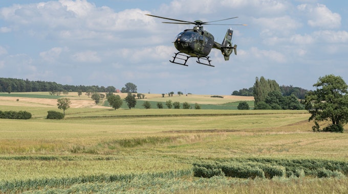 Ein Hubschrauber der Bundeswehr vom Typ Eurocopter EC-135 fliegt über ein Feld. (Symbolbild)