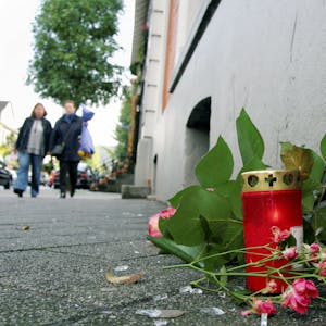 An dem Tatort steht eine Kerze neben Blumen, die auf dem Boden liegen.&nbsp;