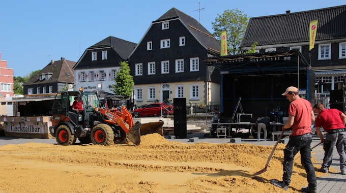 Sand wird auf dem Wipperfürther Marktplatz verteilt.