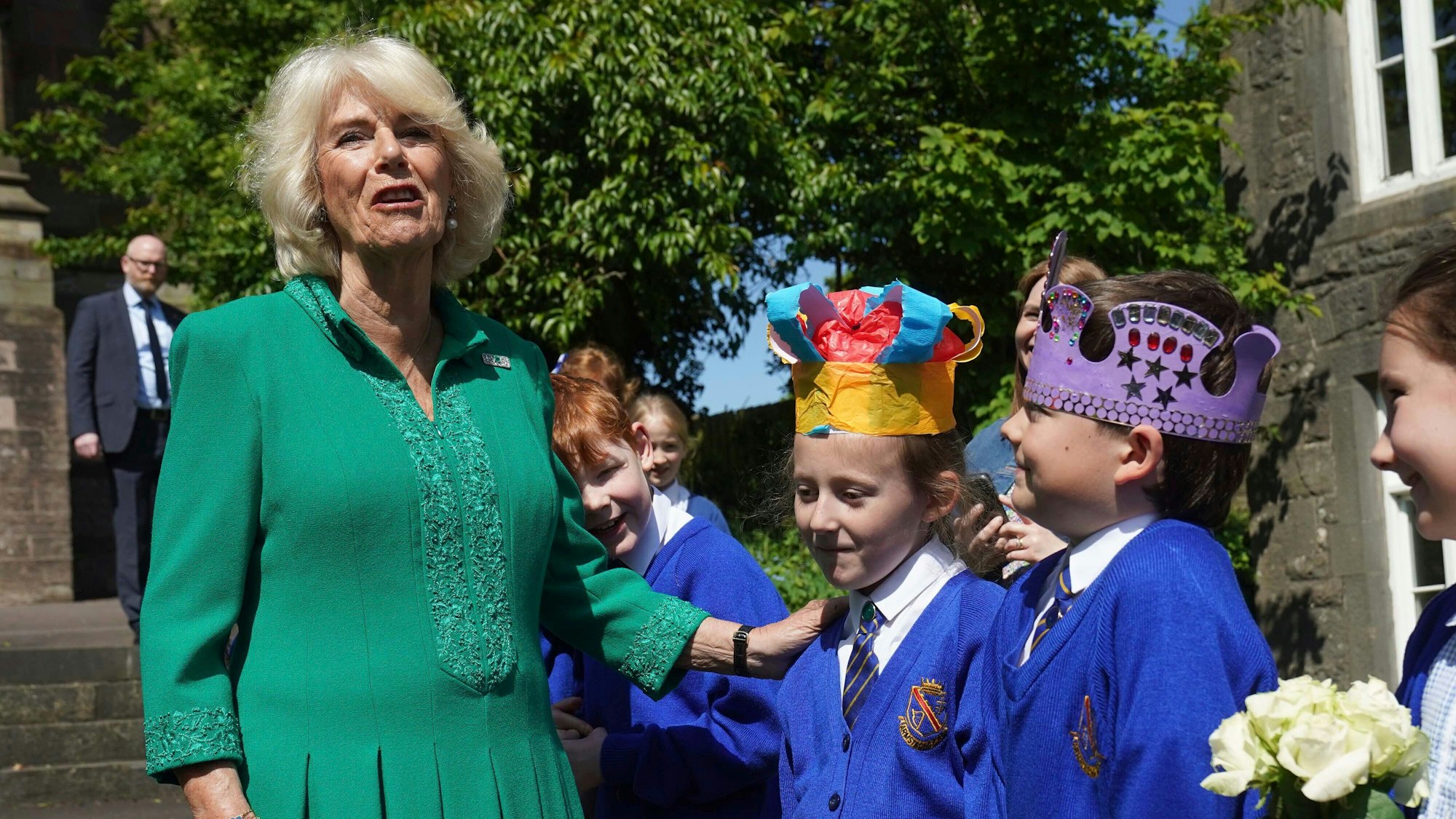 Königin Camilla lacht mit Schulkindern.