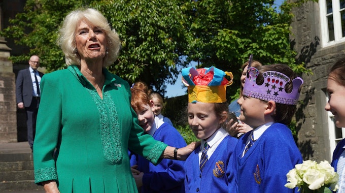 Königin Camilla lacht mit Schulkindern.