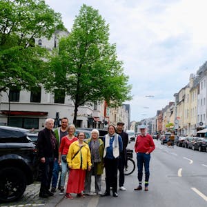 Eine Gruppe Menschen steht am Rand der Berrenrather Straße.&nbsp;