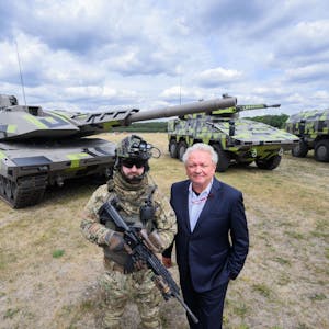 Der Rheinmetall-Vorstandsvorsitzende Armin Papperger (r) und ein Soldat stehen vor einem Kampfpanzer Panther KF51 (l) des Rüstungskonzerns Rheinmetall bei einer Führung durch das Rheinmetall-Werk Unterlüß.