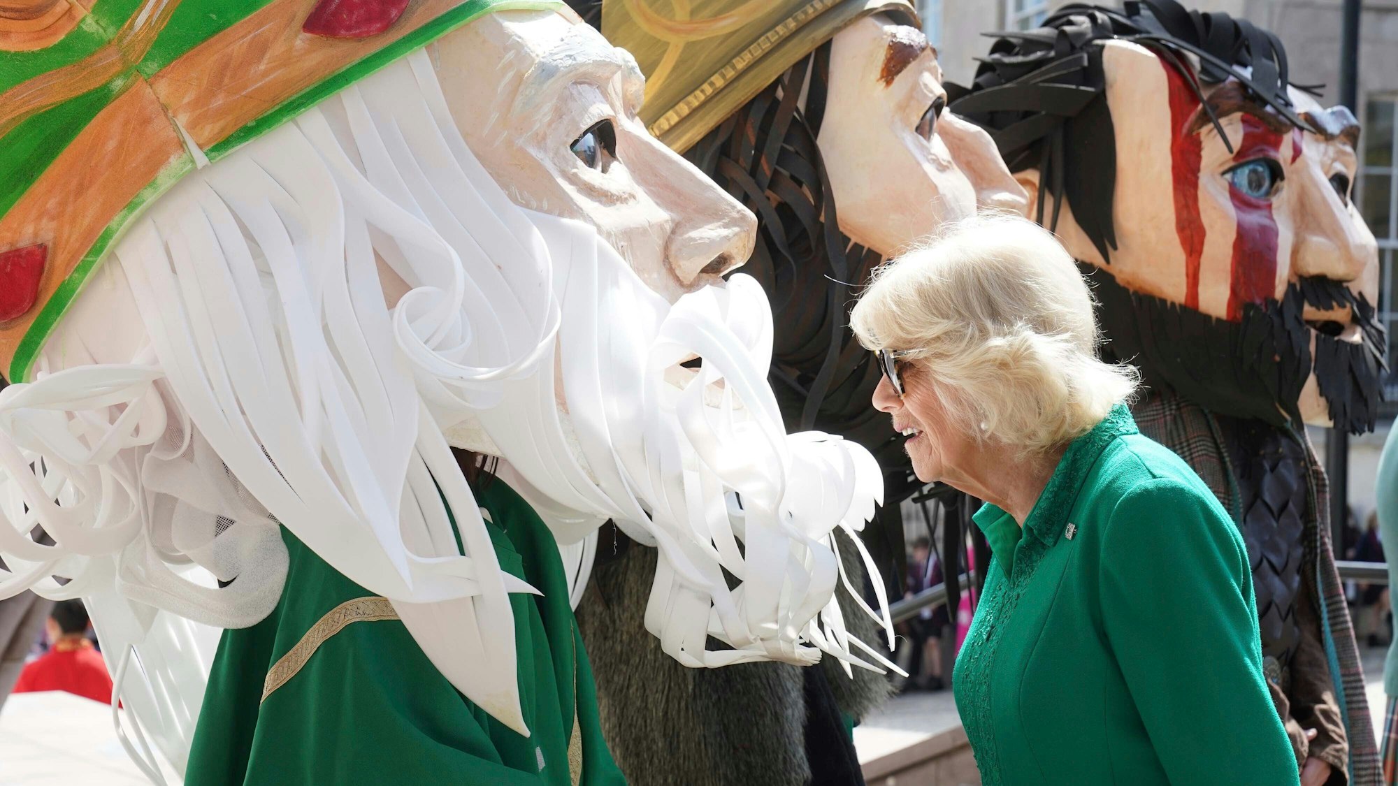 Die britische Königin Camilla trifft bei einem Besuch auf dem Market Theatre Square auf Figuren, die legendäre und historische Persönlichkeiten darstellen, die mit Armagh verbunden sind.