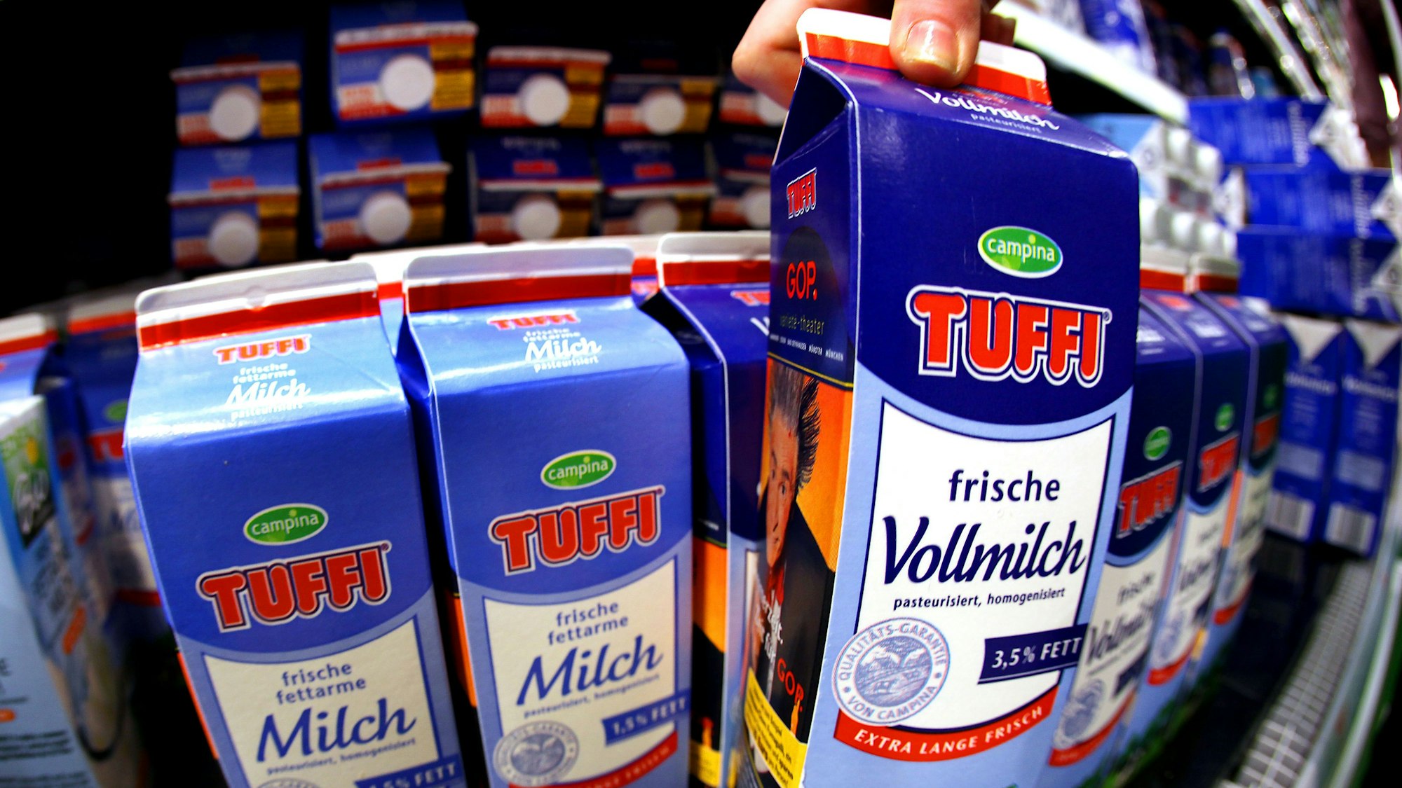 Eine Kundin nimmt in Köln eine Milchpackung (Campina/Tuffi) aus dem Kühlregal
