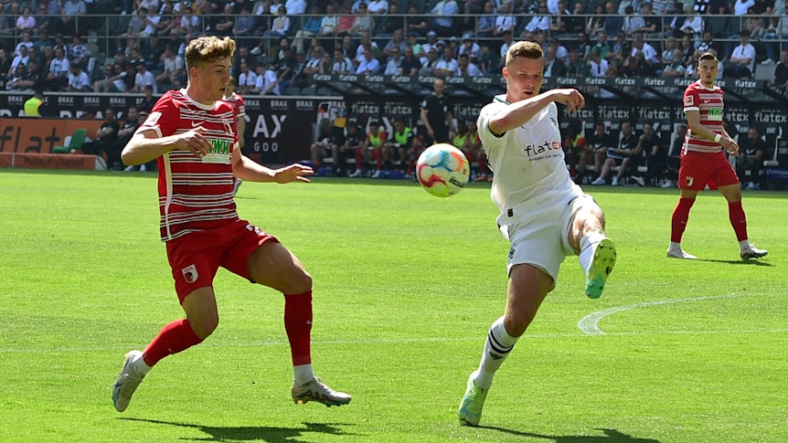 Borussia Mönchengladbach hat am Samstag (27. Mai 2023) 2:0 gegen den FC Augsburg gewonnen. Das Foto zeigt FCA-Profi Arne Engels (l.) im Kampf um den Ball mit BMG-Verteidiger Nico Elvedi (r.).