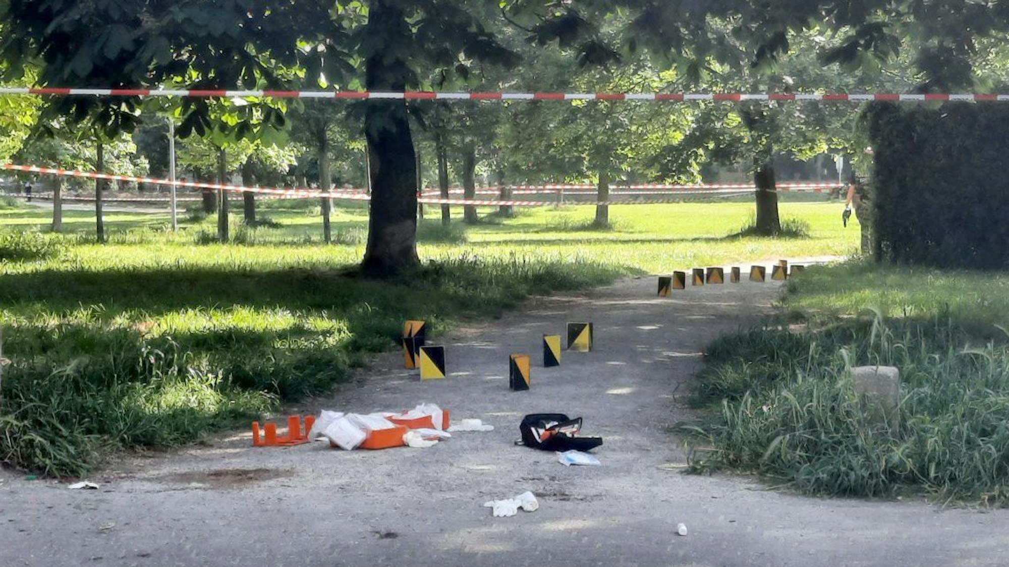 Markierungen der Polizei dokumentieren den Tatort in einem abgesperrten Bereich im Böcking-Park in Köln-Mülheim.