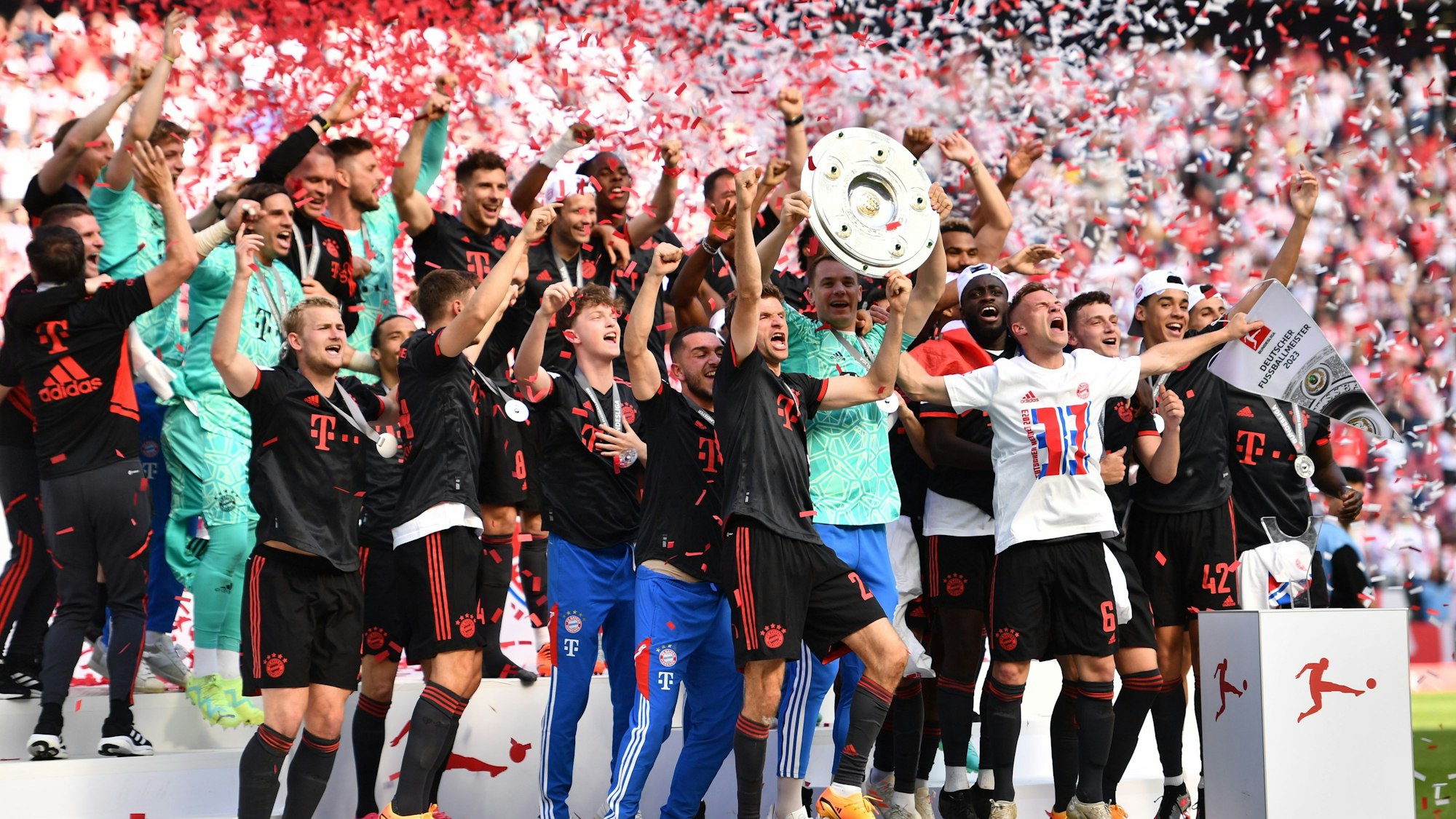Bayerns Torhüter Manuel Neuer (Mitte r) hält die Meisterschale hoch, während seine Teamkollegen nach dem Gewinn der 33. deutschen Meisterschaft jubeln.