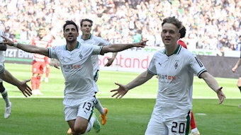 Luca Netz (r.) und Lars Stindl jubeln über einen Treffer von Borussia Mönchengladbach im Bundesliga-Finish (27. Mai 2023) gegen den FC Augsburg im Borussia-Park. Sie breiten die Arme zum Jubel aus.
