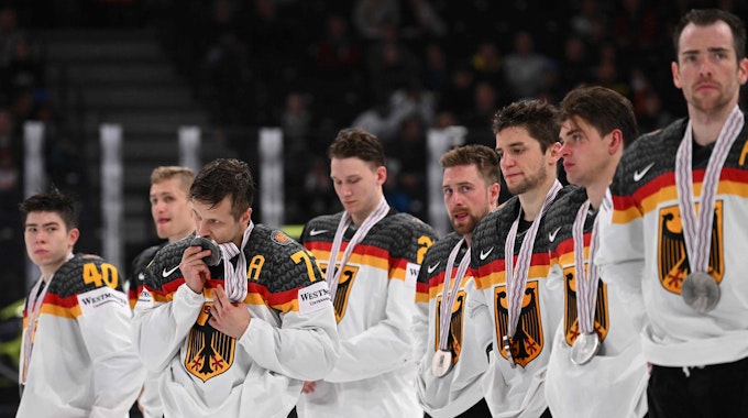 Die deutschen Spieler stehen in einer Reihe. Dominik Kahun küsst seine Medaille.
