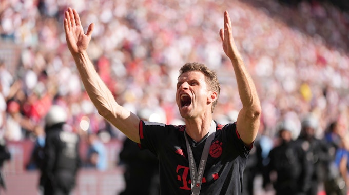 Thomas Müller feiert mit den Bayern-Fans.