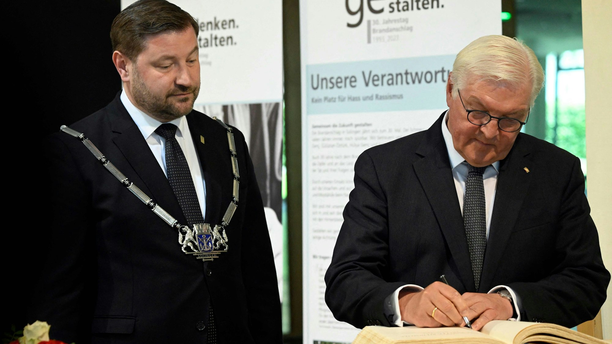 Bundespräsident Frank-Walter Steinmeier (rechts) trägt sich in das Goldene Buch Solingens ein, neben im der Bürgermeister der Stadt, Tim Kurzbach.