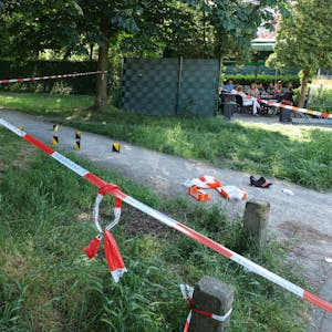 Polizeiabsperrung mit Flatterband direkt neben einem Biergarten am Clevischen Ring in Mülheim.