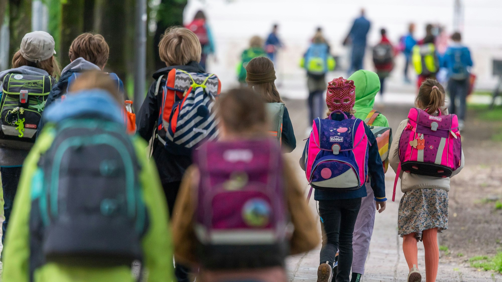 Kinder mit Schulranzen laufen zu Schule.