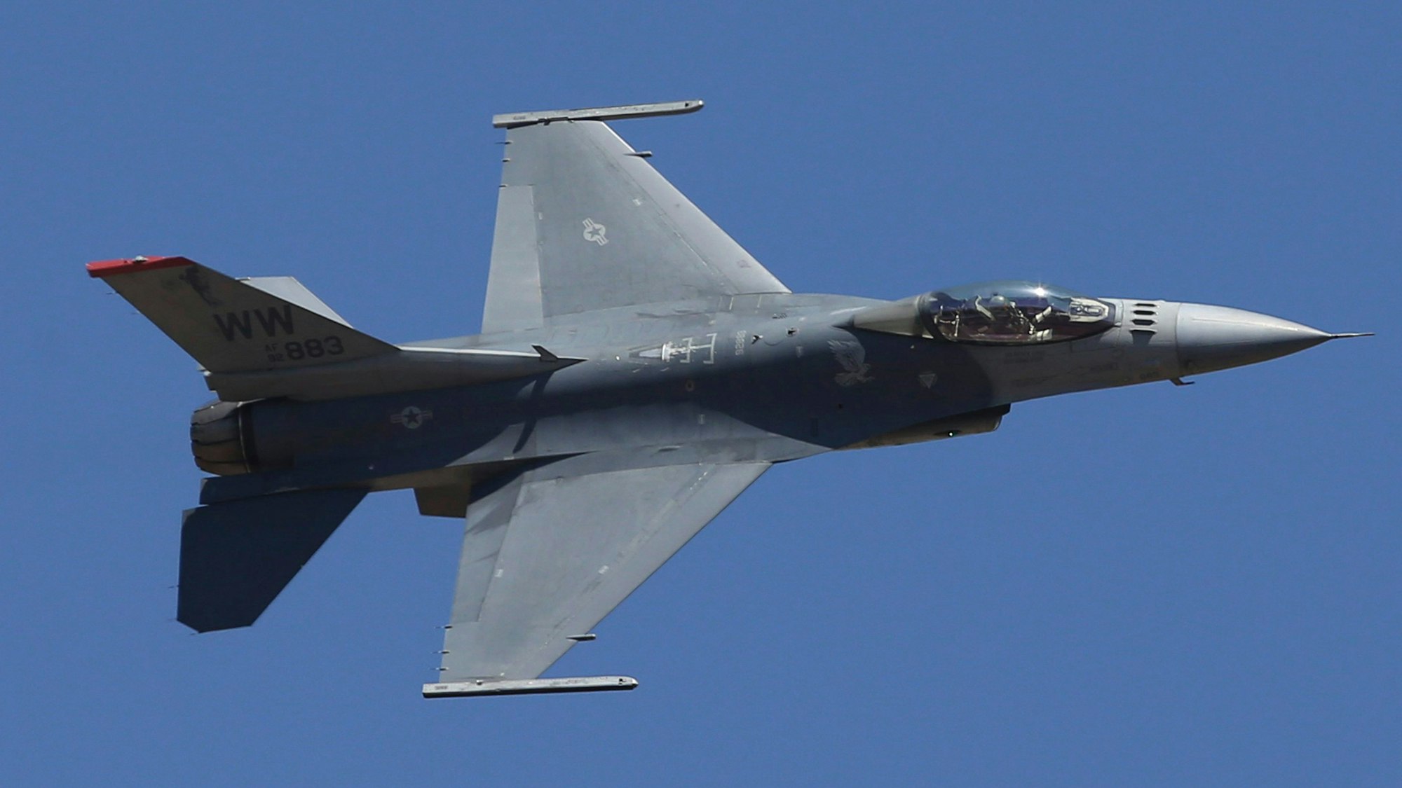 Ein US-Kampfflugzeug vom Typ F-16 fliegt am Himmel.