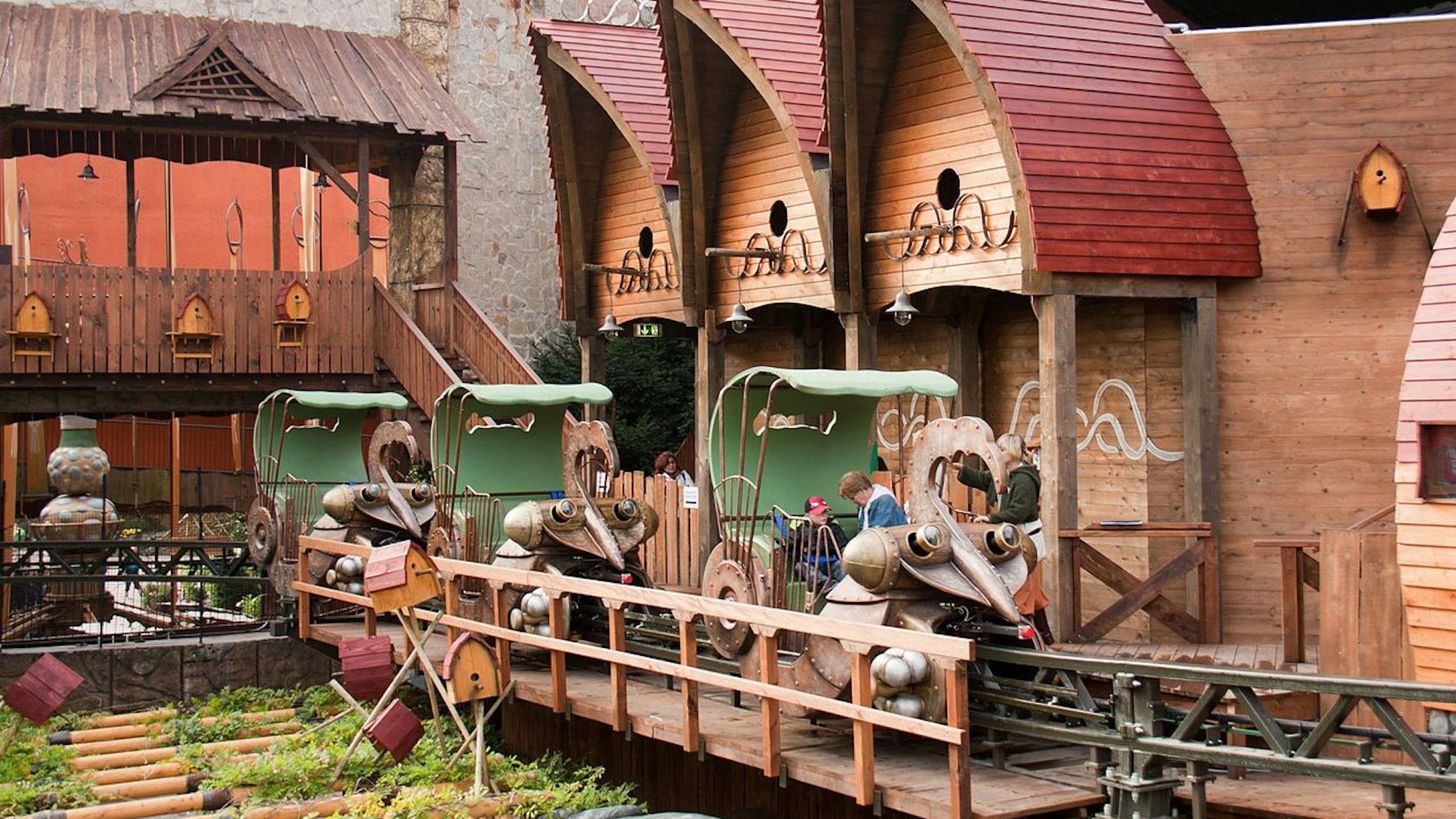 Fahrgäste steigen in die fantasievoll gestalteten Gondeln des Würmling Express im Phantasialand.