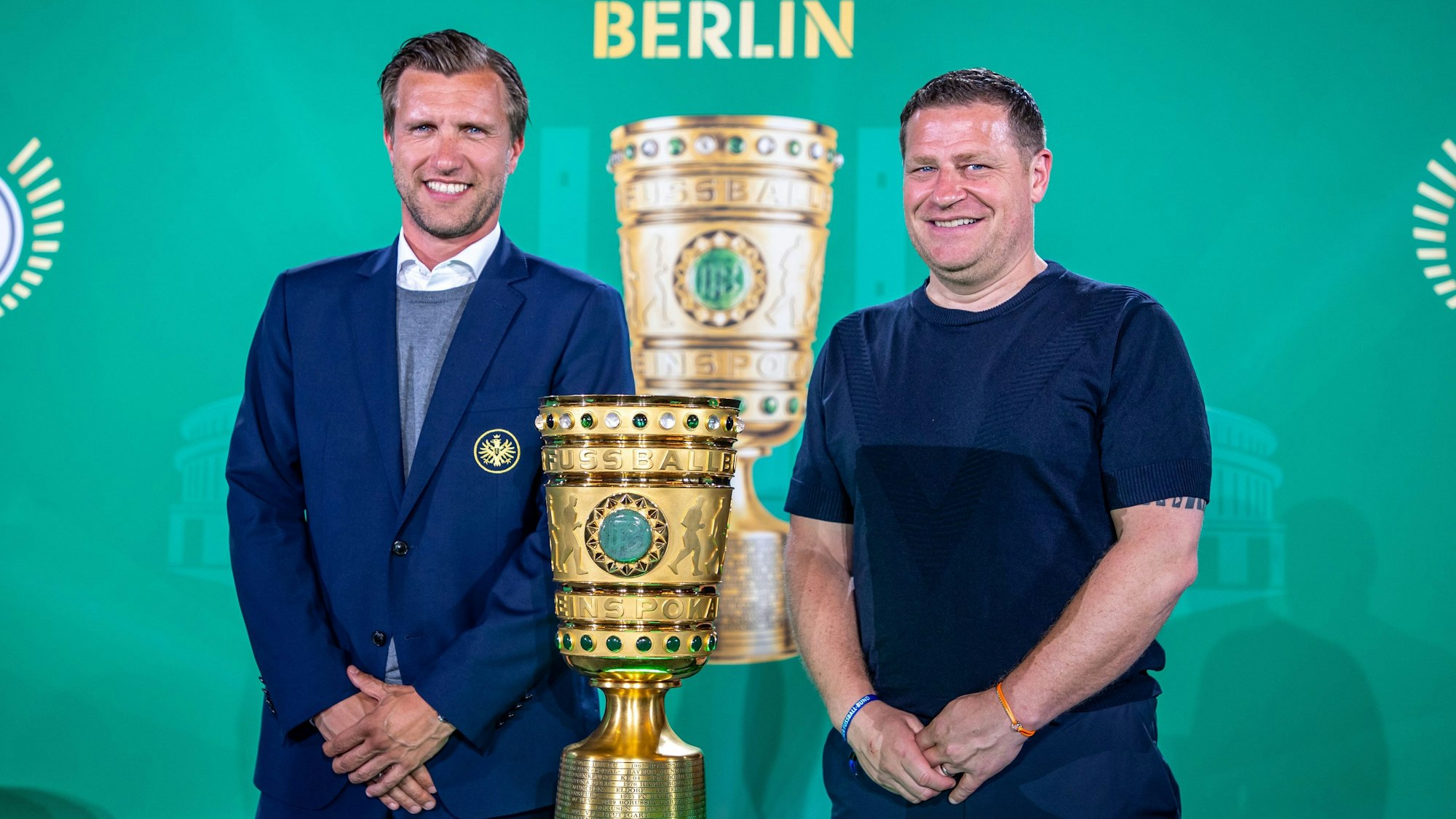 Markus Krösche (l.), Sportvorstand von Eintracht Frankfurt, und Max Eberl, Sportvorstand von RB Leipzig, posieren beim Cup Handover DFB-Pokal 2023 im Roten Rathaus neben der Trophäe.