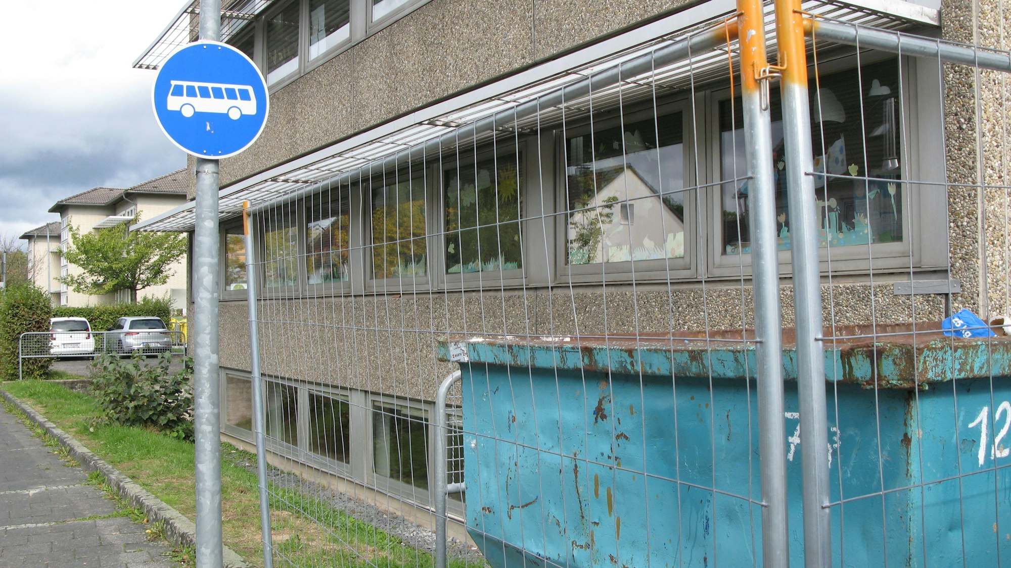 Die Kita in Hennef befindet sich hinter einem Bauzaun. Vor dem Zaun steht ein Schild, das darauf hinweist, dass hier nur Busse langfahren dürfen.