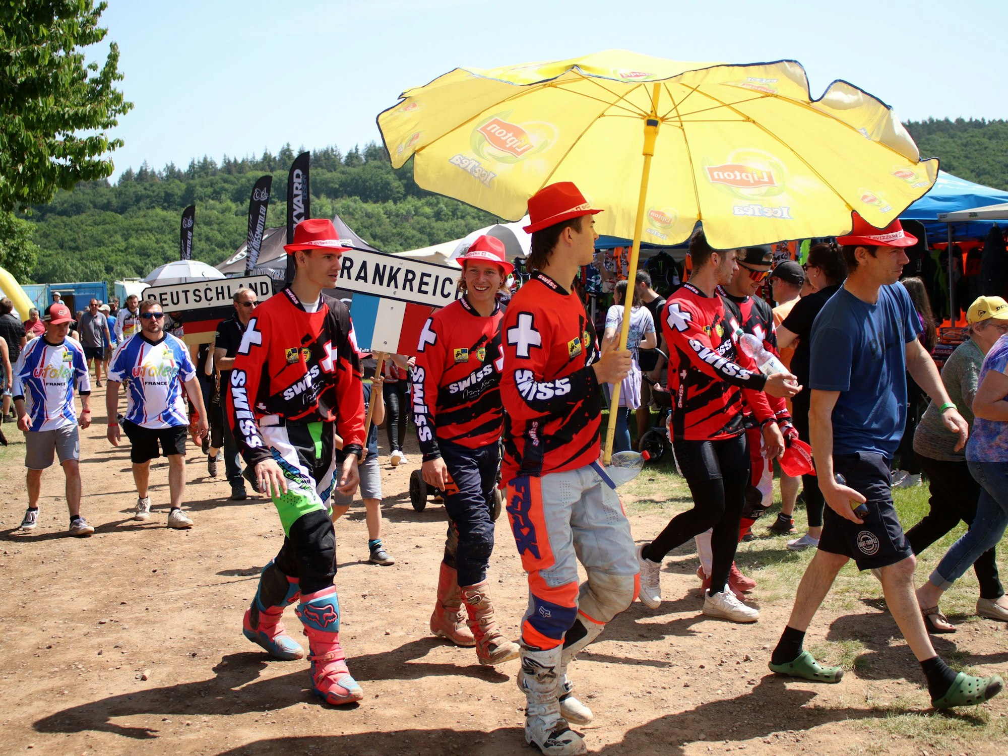 Das Team der Schweiz mit roten Hüten. Ein Fahrer trägt einen gelben Schirm.