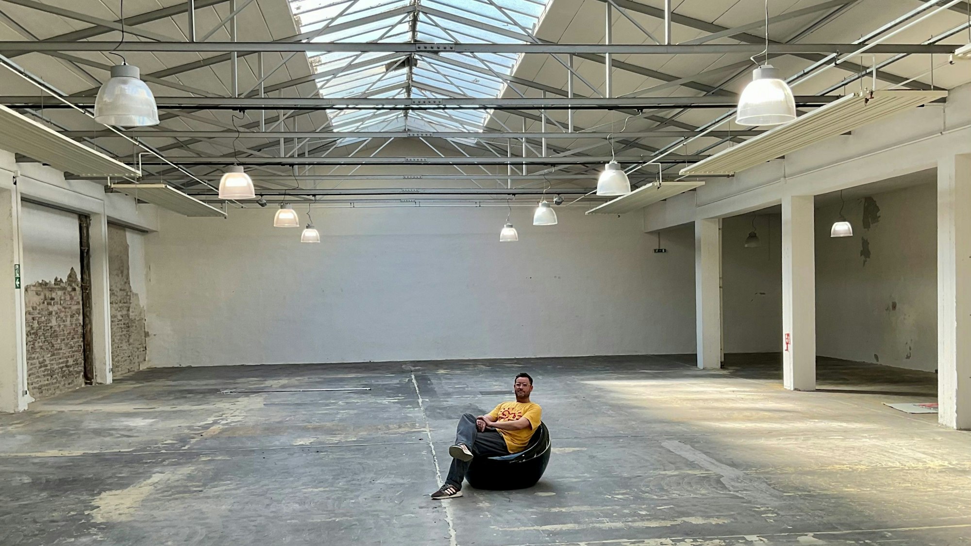 Ein Mann sitzt in einer leeren alten Halle