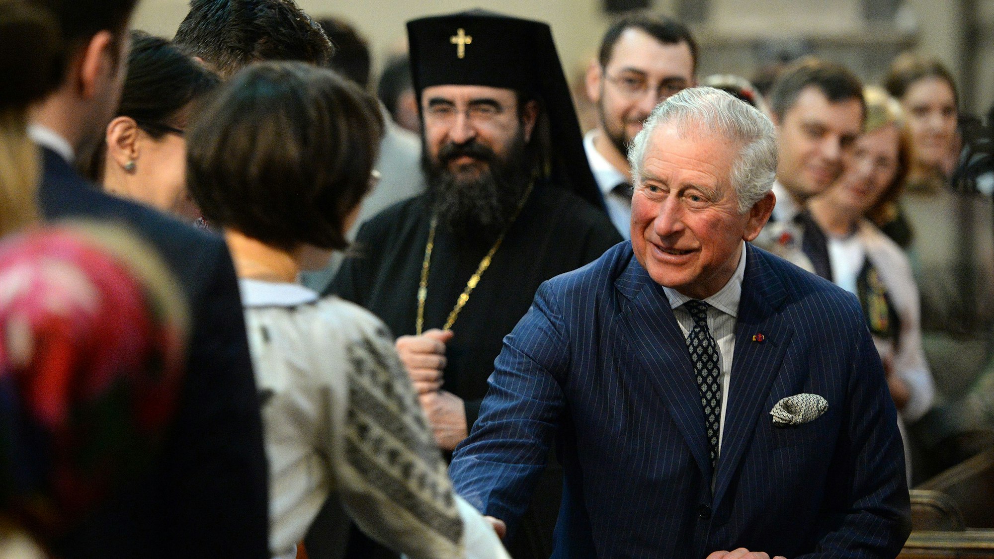 Der damalige Prinz Charles bei einem offiziellen Besuch in Rumänien. Im Hintergrund sieht man Ihre Eminenz Joseph Pop, Erzbischof der rumänisch-orthodoxen Erzdiözese von West- und Mitteleuropa, anlässlich eines rumänisch-orthodoxen Gottesdienstes