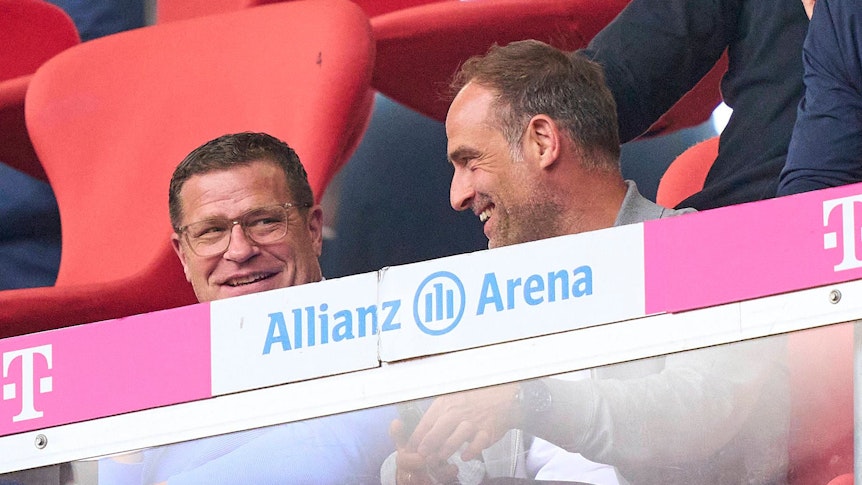 RB-Sportgeschäftsführer Max Eberl (l.) und Oliver Mintzlaff (r.), Geschäftsführer RB Leipzig, hier zu sehen am 20. Mai 2023 während der Bundesligapartie bei Bayern München in der Allianz-Arena. Beide lächeln.