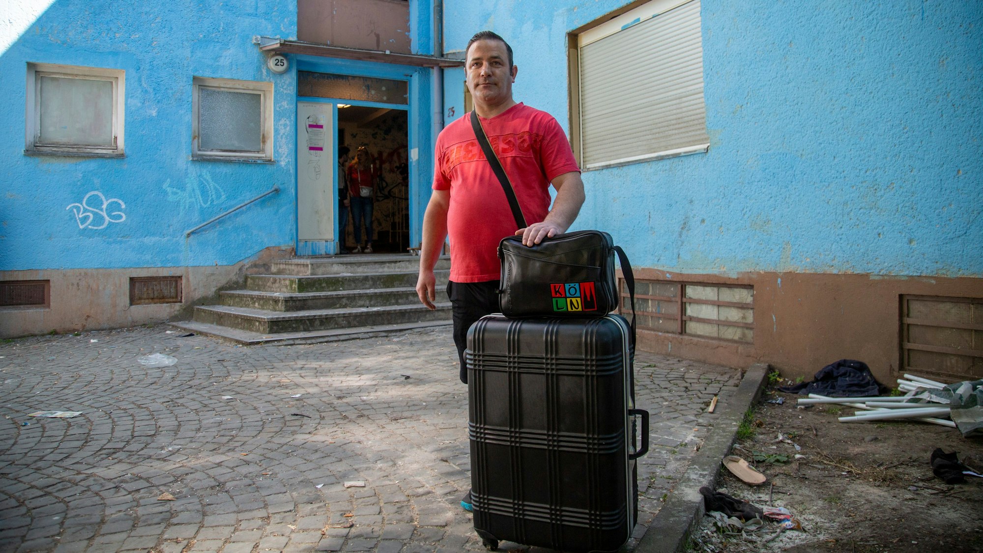 Ein ehemaliger Bewohner des OMZ steht mit seinen Koffern vor dem Haus auf der Gummersbacher Straße.