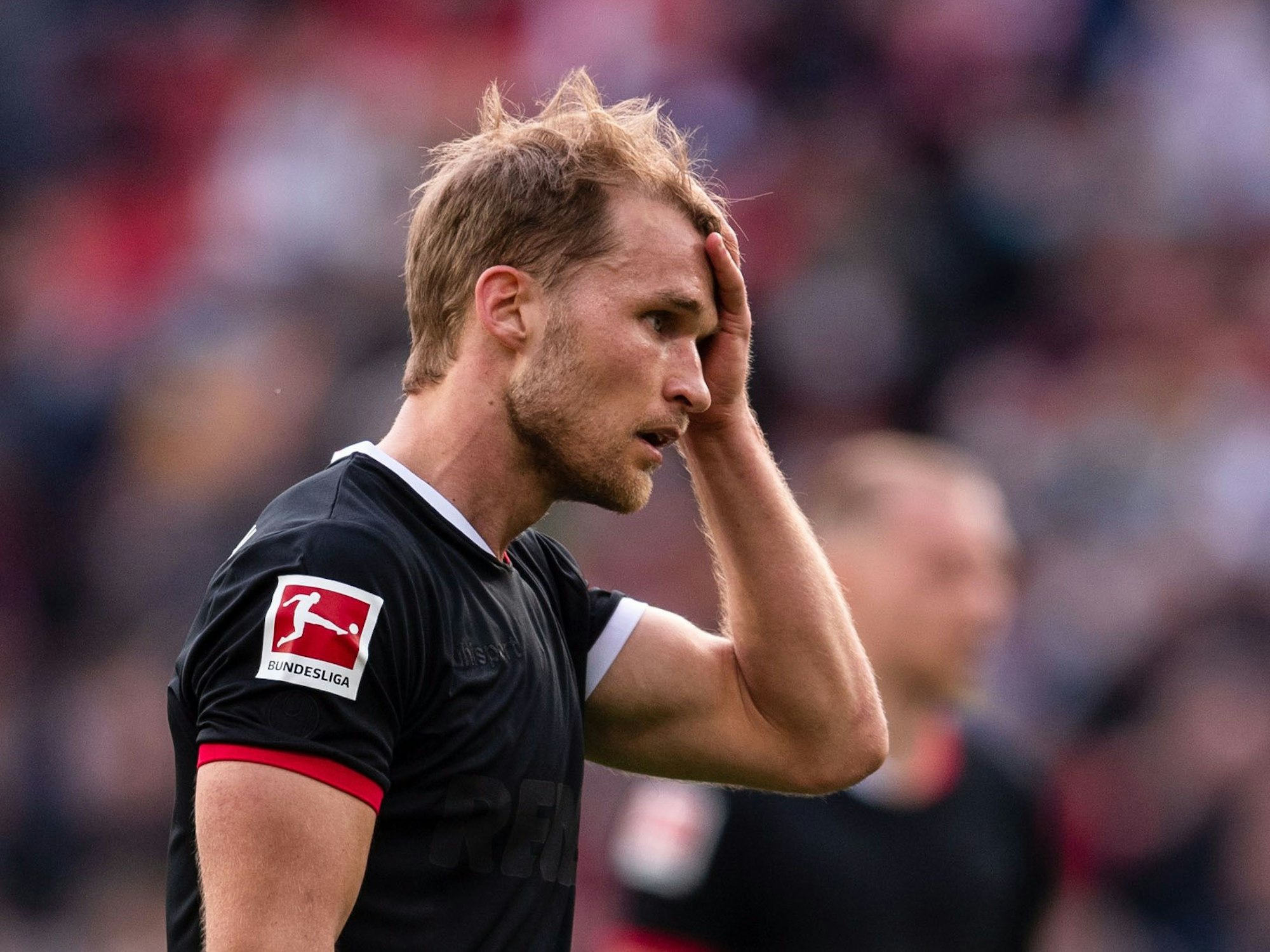 Sebastian Andersson trägt ein schwarzes FC-Trikot und fasst sich an den Kopf.