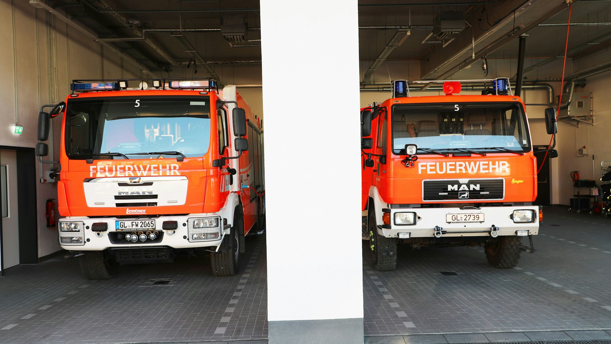 Einsatzfahrzeuge der Feuerwehr stehen in der Fahrzeughalle des neuen Feuerwehrhauses in Bergisch Gladbach-Schildgen.