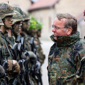 Es ist Boris Pistorius in Kleidung der Bundeswehr zu sehen. Er ist umgeben von mehreren Soldaten.&nbsp;