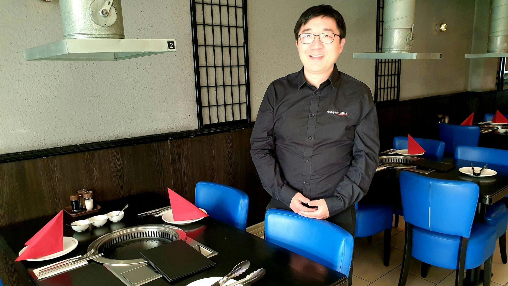 Geschäftsführer Hyun-Jae An steht zwischen den Tischen des Bulgogi-Hauses.