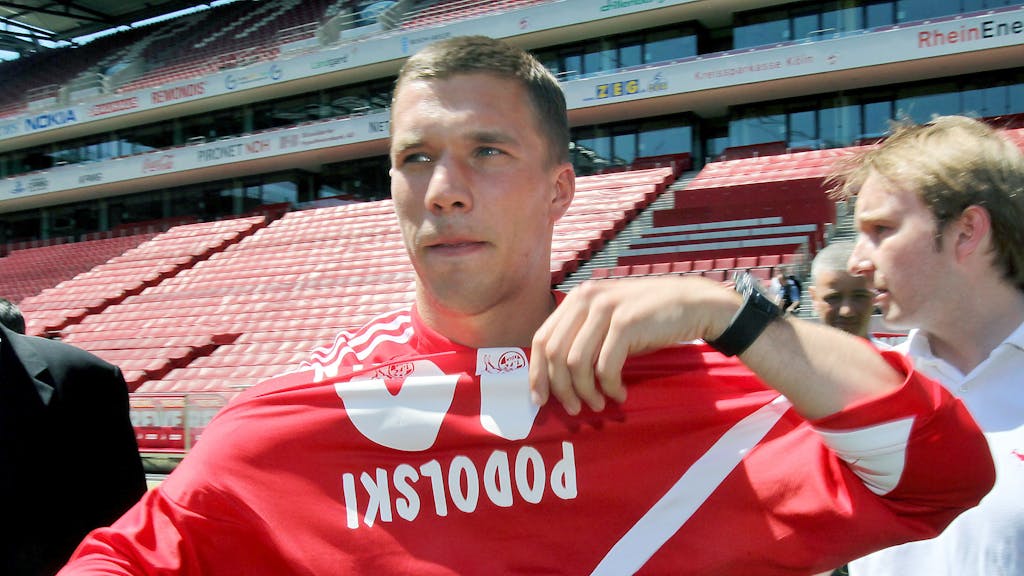 Lukas Podolski zieht sein neues FC-Trikot an.