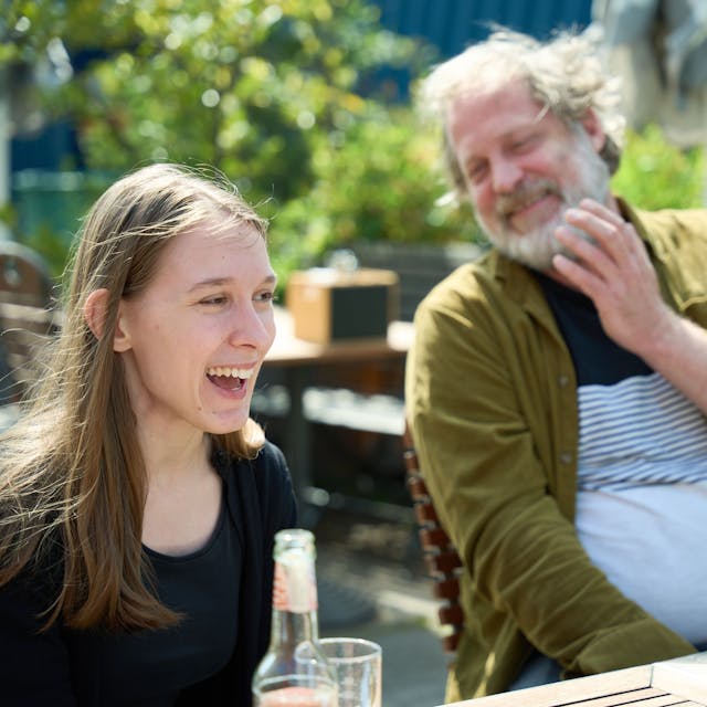 Lorelei Holtmann und Benjamin Höppner sitzen an einem Tisch und sind am Lachen.