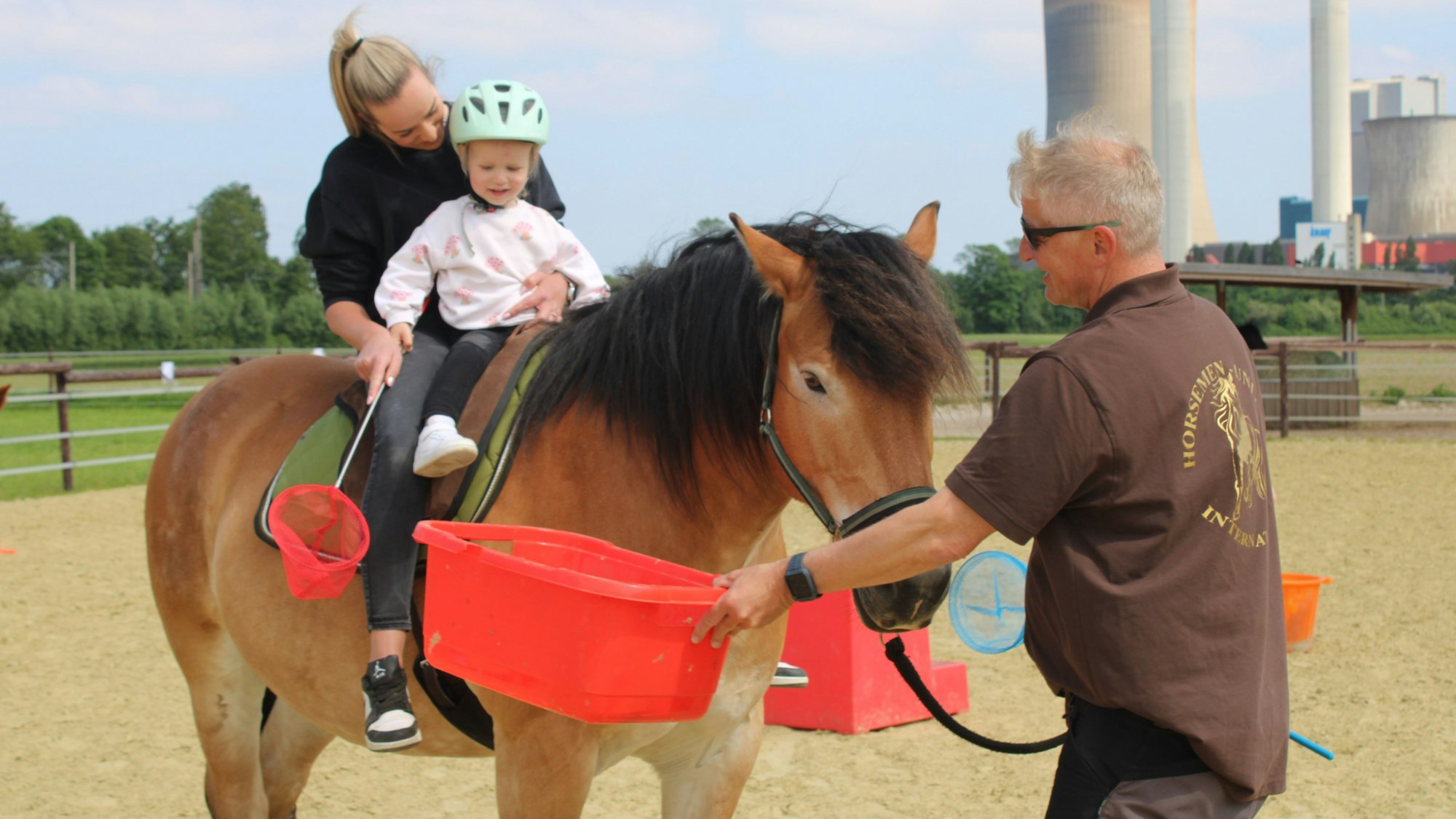 Auf dem Pferd ist zu sehen, wie Sarah Strupp und ihre Tochter Lena auf dem Rücken von „Moritz “den Parcours meistern. Thomas Görs hilft ihnen dabei.