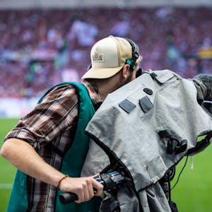 Ein Kameramann filmt vor einem Fußballspiel. (Symbolbild)